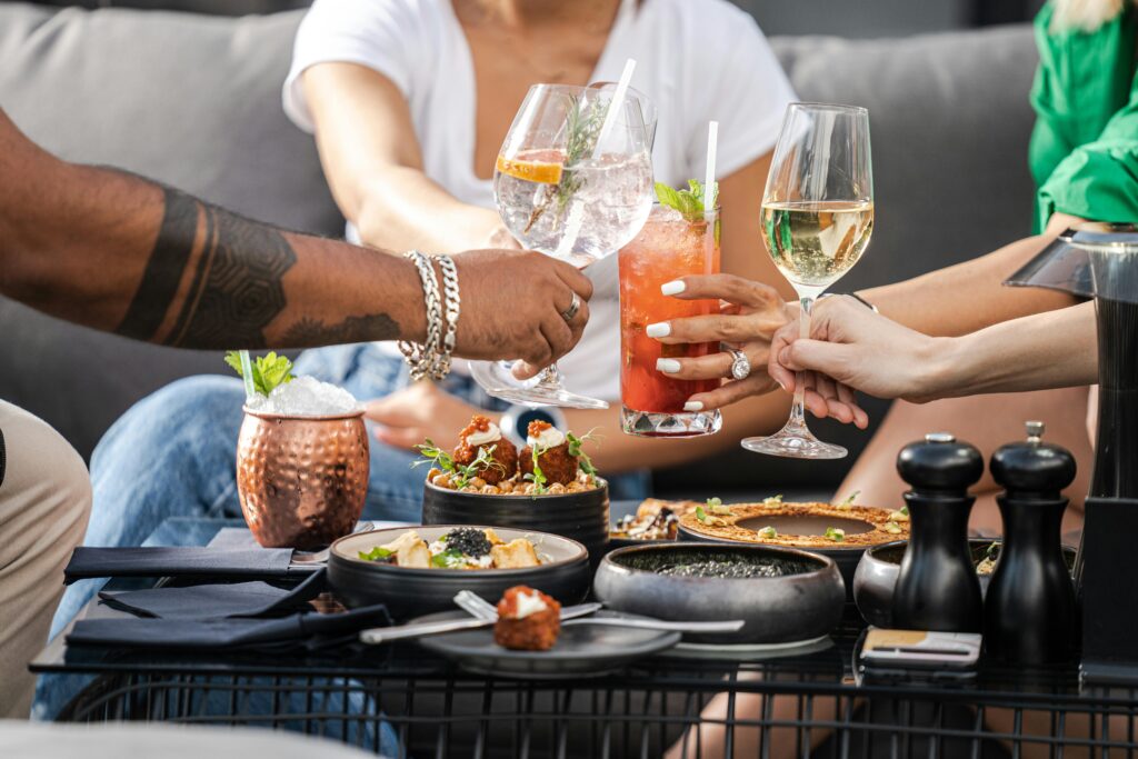 A group of friends enjoying cocktails and appetizers at an outdoor gathering in Dubai.